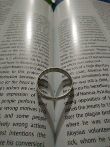 Ring with a shadow in a heart shape in the spine of a book